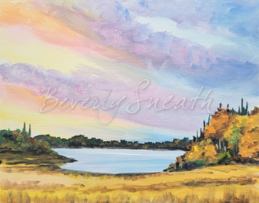 pastel clouds in sky over a lake, golden grass and autumn trees