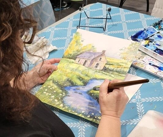 Woman painting watercolour landscape
