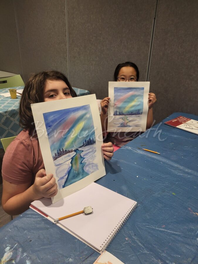 Kids with their watercolour paintings of a winter scene